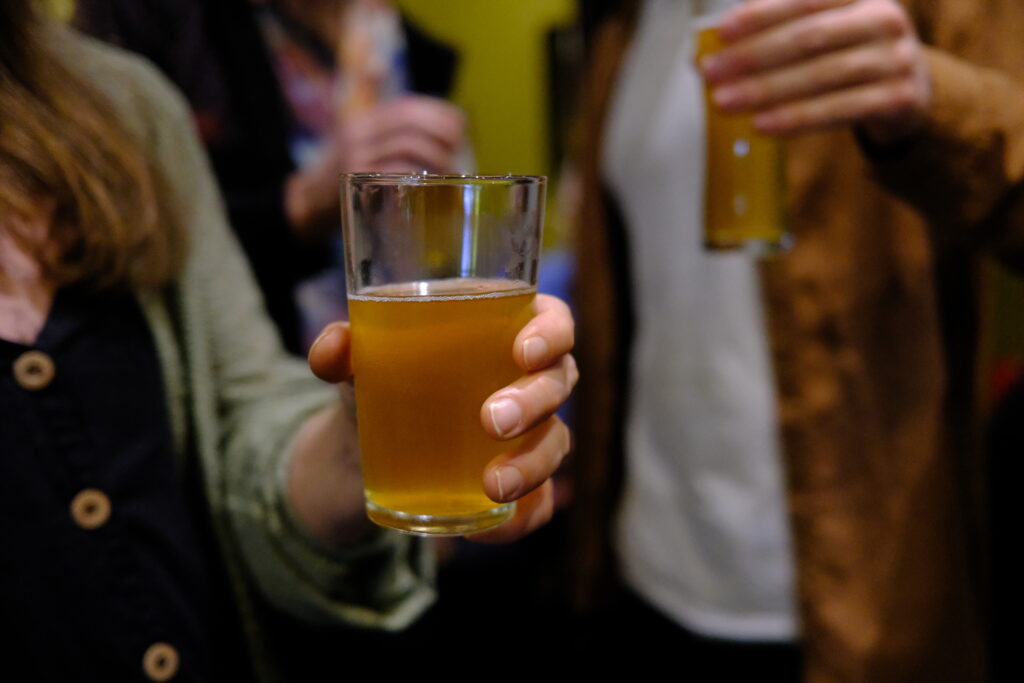 Pint glass of cider held by woman